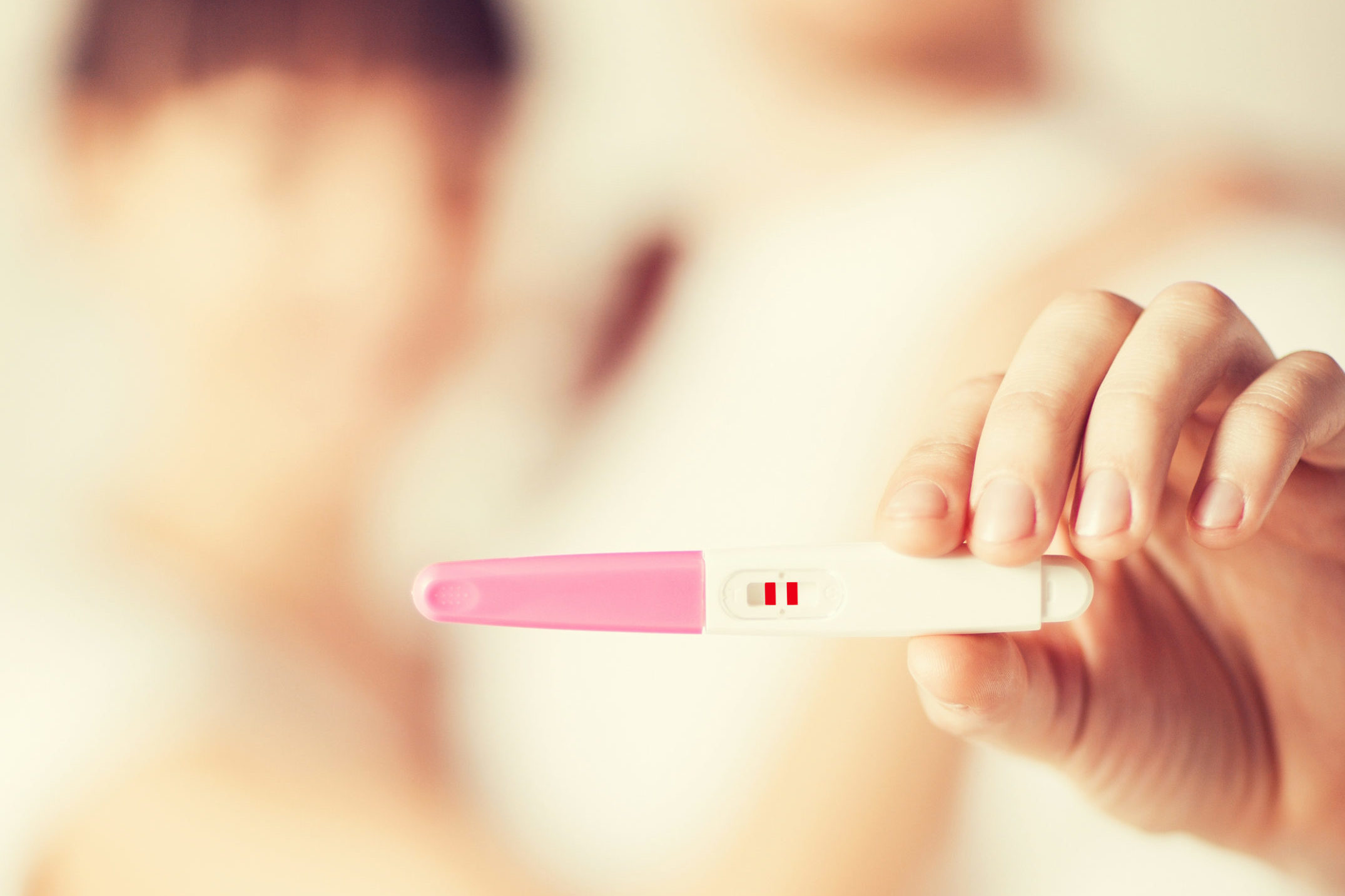 woman and man hands with pregnancy test