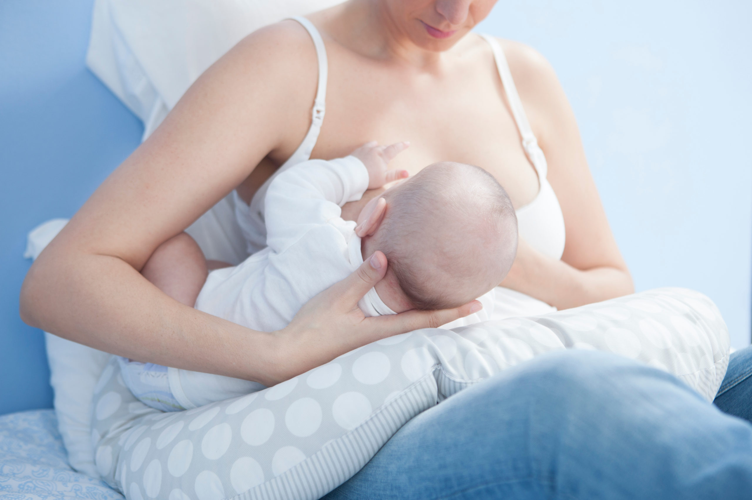 Mother feeding breast with nursing pillow