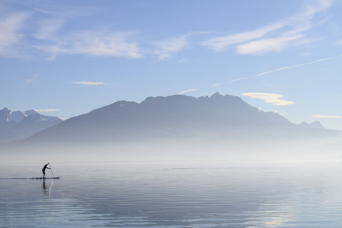 Personnes pratiquant le paddle sur le lac d'Annecy avec vue sur les montagnes