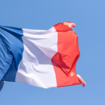 Documents de demande de nationalité française avec le drapeau français en arrière-plan