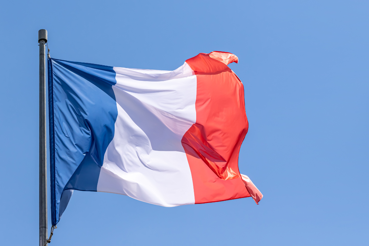 Documents de demande de nationalité française avec le drapeau français en arrière-plan