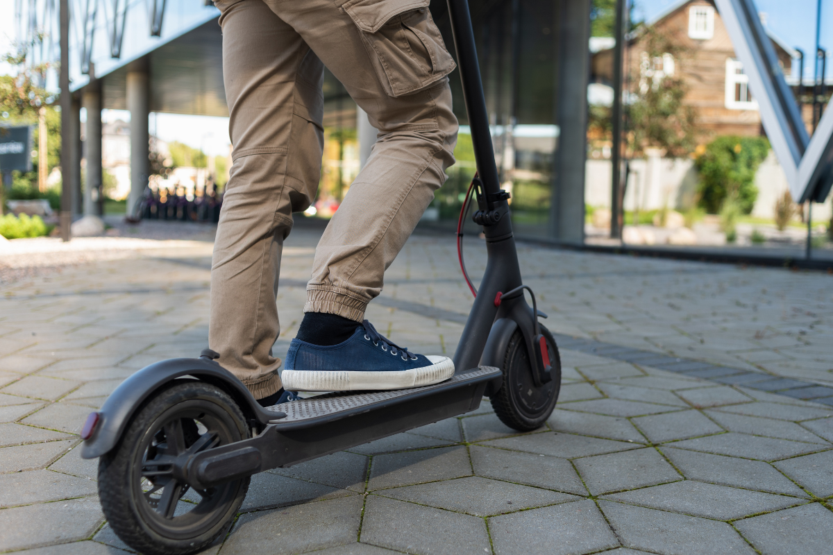 Personne utilisant une trottinette électrique avec des icônes de protection et d'assurance