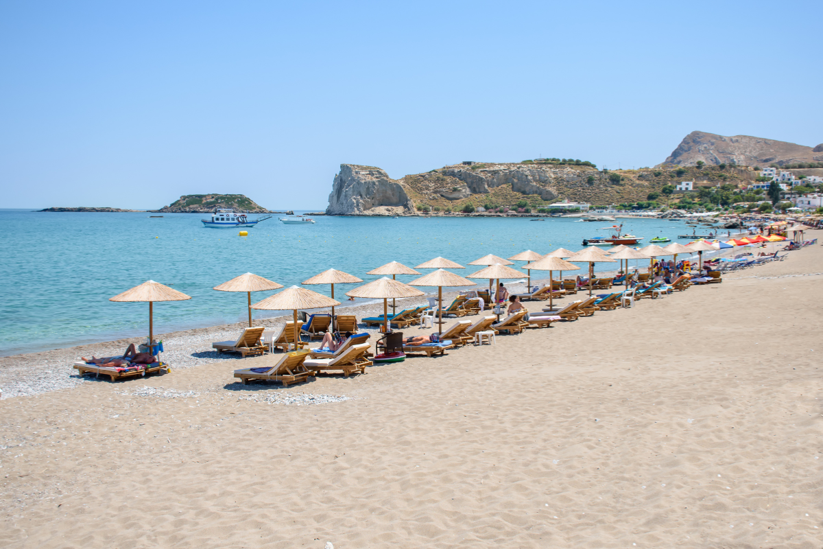 Plage ensoleillée avec des vacanciers se détendant sous des parasols en décembre