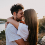 Un couple en train de discuter, l'homme chuchotant des mots doux à l'oreille de la femme qui sourit