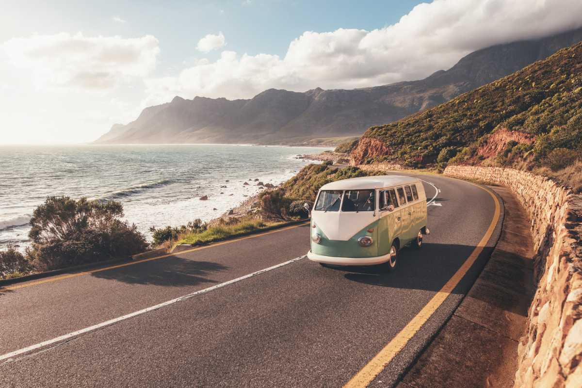 Van aménagé pour un road trip avec une route panoramique en arrière-plan