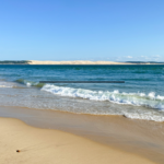 Vue panoramique d'une plage idyllique au Cap Ferret avec sable fin et océan bleu