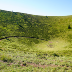 Vue aérienne des puys emblématiques d'Auvergne, avec des volcans verdoyants sous un ciel bleu