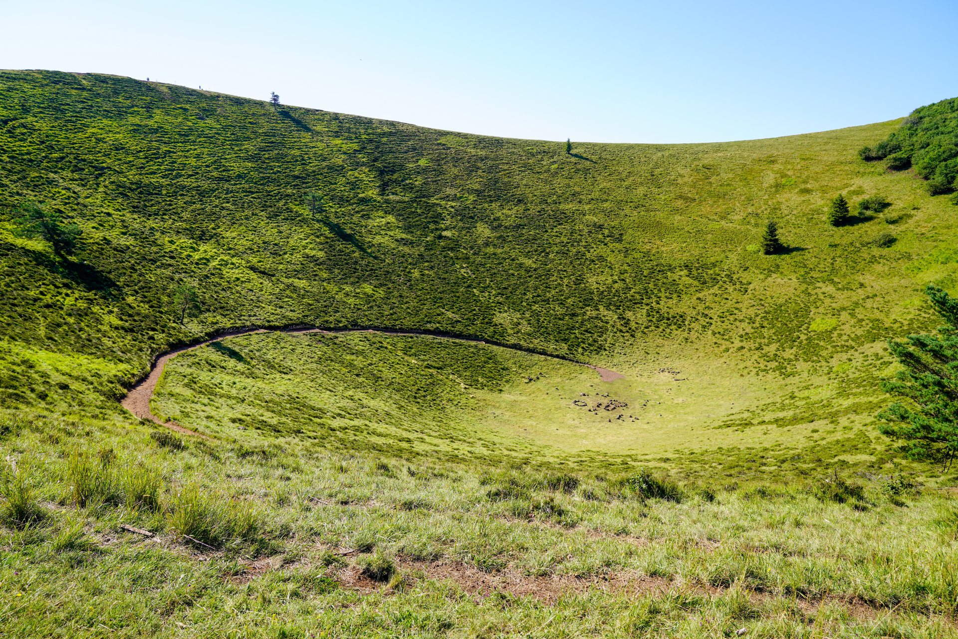 Vue aérienne des puys emblématiques d'Auvergne, avec des volcans verdoyants sous un ciel bleu