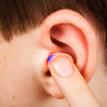 Personne insérant correctement un bouchon d'oreille en mousse