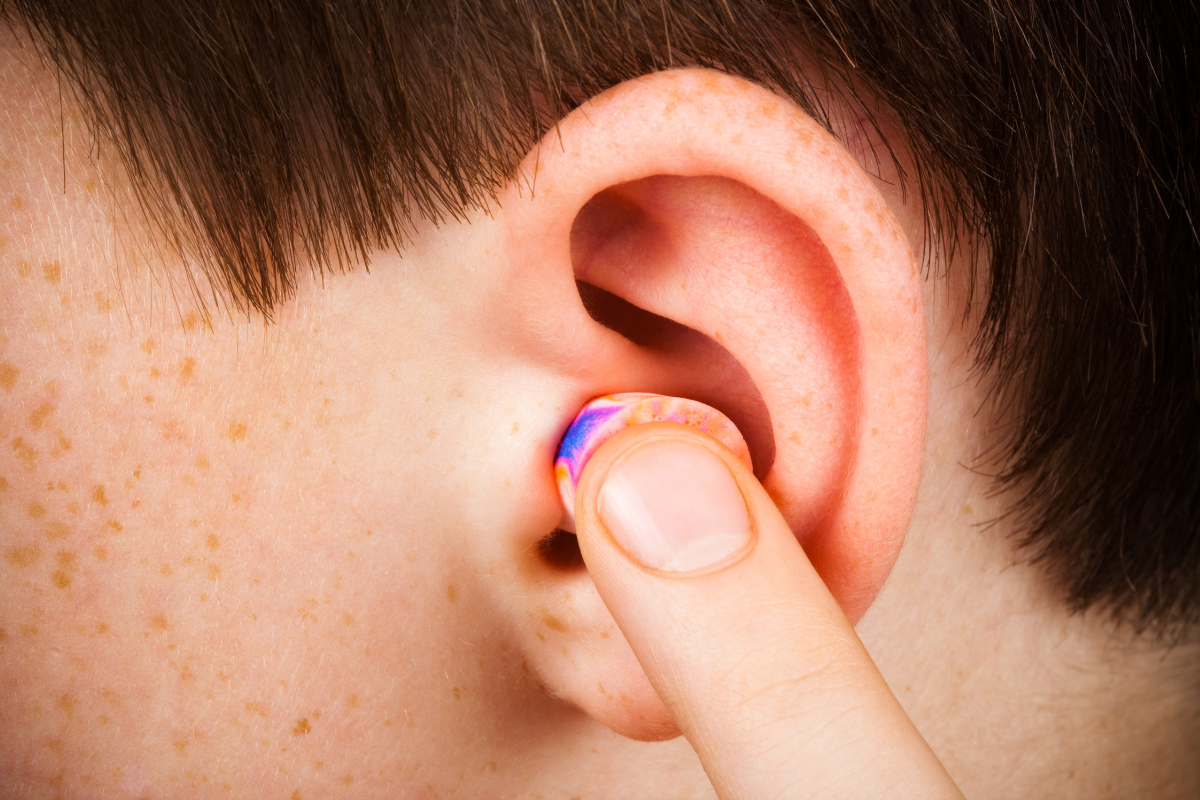 Personne insérant correctement un bouchon d'oreille en mousse